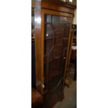 A reproduction mahogany corner cupboard with astragal glazed door