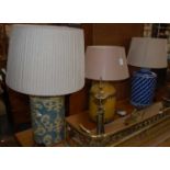 A group of three contemporary tea tin table lamps, one blue with white coral painted detail, one