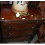 An early 20th century reproduction mahogany straight front bachelors chest with pull-out brush slide