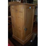 A late 19th century pine pot cupboard enclosing a white ceramic chamber pot