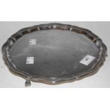 A Sheffield sterling silver salver with scalloped edge raised on three scroll feet, 15.4 Troy Ozs