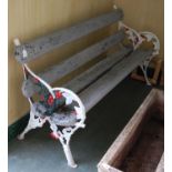 A late 19th century cast iron garden bench with fruit and foliate details picked out in white, green