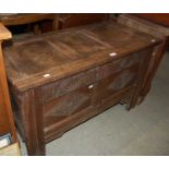 An antique oak coffer with double panelled front