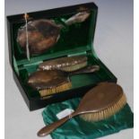 A cased Birmingham silver three-piece dressing table set comprising mirror and two brushes, together
