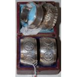 A cased pair of Sheffield silver napkin rings, together with two other silver napkin rings