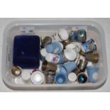 A box of assorted white metal, ceramic and other thimbles