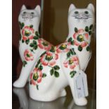 A pair of Griselda Hill pottery Wemyss style cats, decorated with dog roses, 18cm high