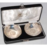 A cased pair of Indian silver coin-set bowls, each set with an Indian one Rupee coin dated 1919, the