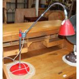 A chrome and red industrial style table lamp