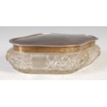 A George V silver mounted cut glass quatrefoil shaped dressing table box and cover,