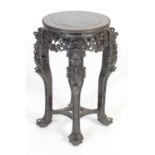 A Chinese dark wood urn stand,