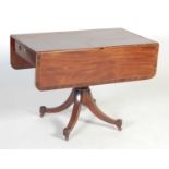 A Regency mahogany, rosewood and boxwood lined drop leaf pedestal table,