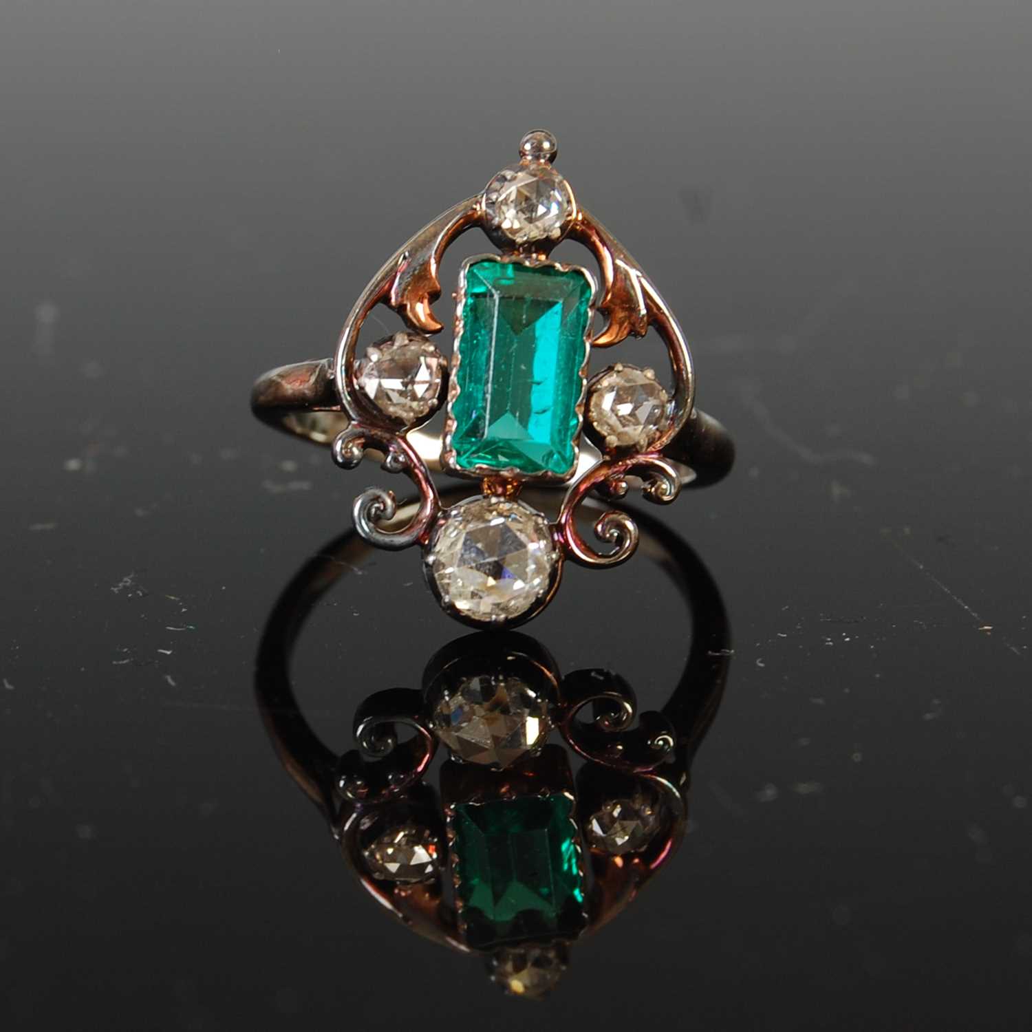 An early 20th century white and yellow metal emerald and diamond set cocktail ring,