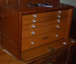 A mid-century Union collectors cabinet, the removable front panel doubles as a slide, with four