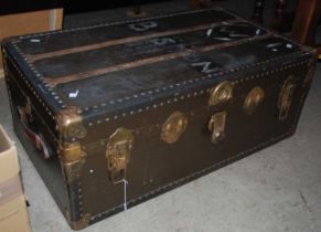 A vintage white metal bound cabin trunk with leather handles on side.