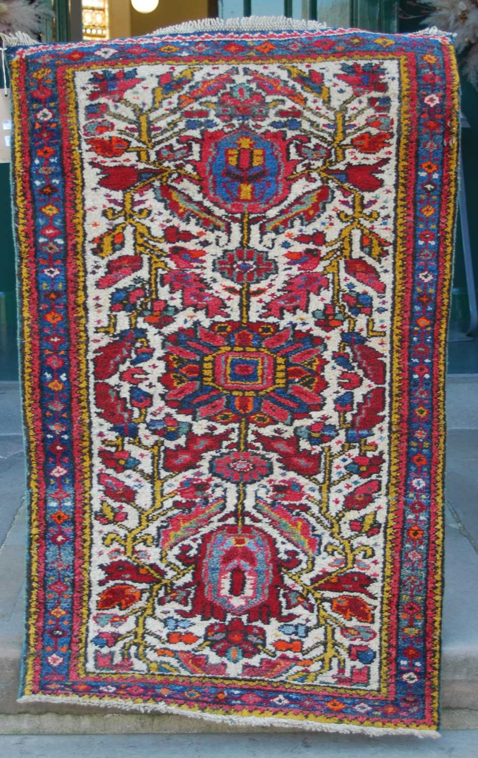 Two small Persian rugs, comprising a brown ground rug decorated with four triangular shaped motifs