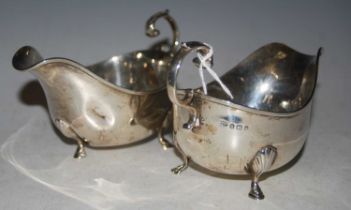 A pair of Birmingham silver sauce boats, each raised on three shell and cabriole supports, 7 troy