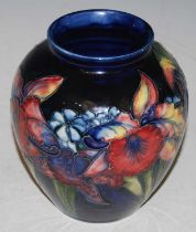 A Moorcroft pottery vase, decorated with iris on a blue ground, impressed marks, blue painted