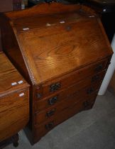 An oak drop-leaf table together with an oak fallfront bureau.