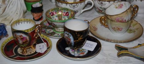 A collection of Continental porcelain cups and saucers comprising a Vienna style tri-footed cup