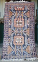 A Persian rug, 20th century, the rectangular blue ground centred with two salmon pink octagonal