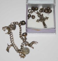 A white metal charm bracelet suspending seven assorted charms together with heart-shaped lock,