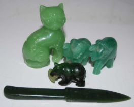 A group of green hardstone carvings to include a letter opener, cat, bear and salmon figure, pair of