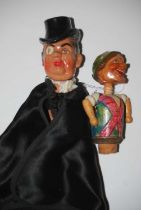 A vintage bottle pourer in the form of a cloaked gentleman wearing a top hat and monocle, together