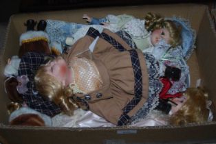 A box of assorted collectors dolls.