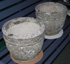 A pair of reconstituted stone garden planters, the exteriors with various fruit details.