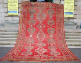 A late 19th century red ground Ushak carpet, the rectangular field decorated with three rows of