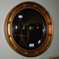 A reproduction Regency style convex gilt wall mirror.