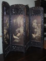 A Japanese silkwork four-division table screen, the carved surround centred with panels of foliage