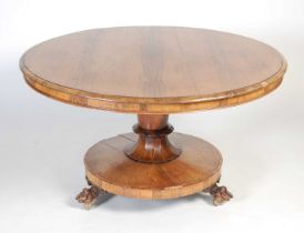 A 19th century rosewood snap-top supper table, the hinged circular top resting on a tapered