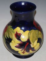 A Moorcroft pottery vase, decorated with hibiscus on a blue ground, impressed marks, blue painted