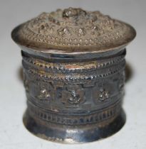 A late 19th / early 20th century Eastern white metal circular box and cover with embossed decoration