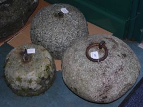 A group of three assorted stone counter weights, each with a metal handle.