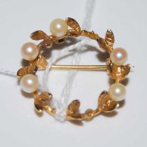 A 9ct gold and pearl set set circular laurel-shaped brooch, gross weight 3.1 grams.