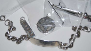 A collection of assorted silver and white metal items to include a name bracelet, ingot, circular