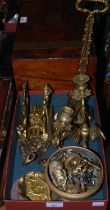 A box of assorted brassware to include a pair of candlesticks in the form of griffins, a door stop