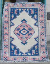 A Persian rug, 20th century, the blue and white rectangular within a pink ground border of