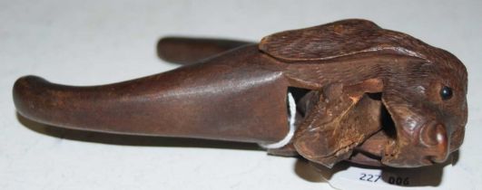 A vintage treen nutcrack carved in the form of a dog's head, 16cm long.