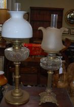 A late 19th/ early 20th century brass oil lamp with white and clear glass shade, with twin
