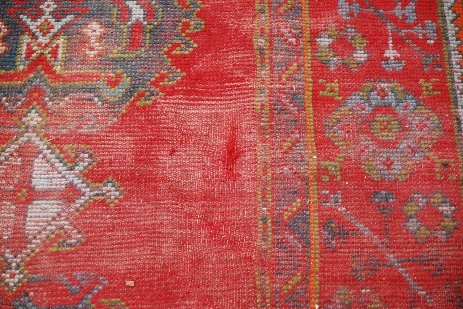A late 19th century red ground Ushak carpet, the rectangular field decorated with three rows of - Image 5 of 9