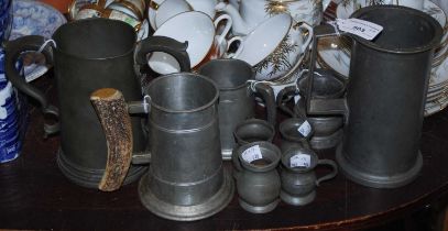 A group of mixed pewter items comprising measures, tankards, one tankard with horn handle, and a