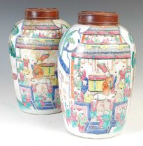 A pair of Chinese porcelain famille rose bullet-shaped jars and wood covers, Qing Dynasty, decorated