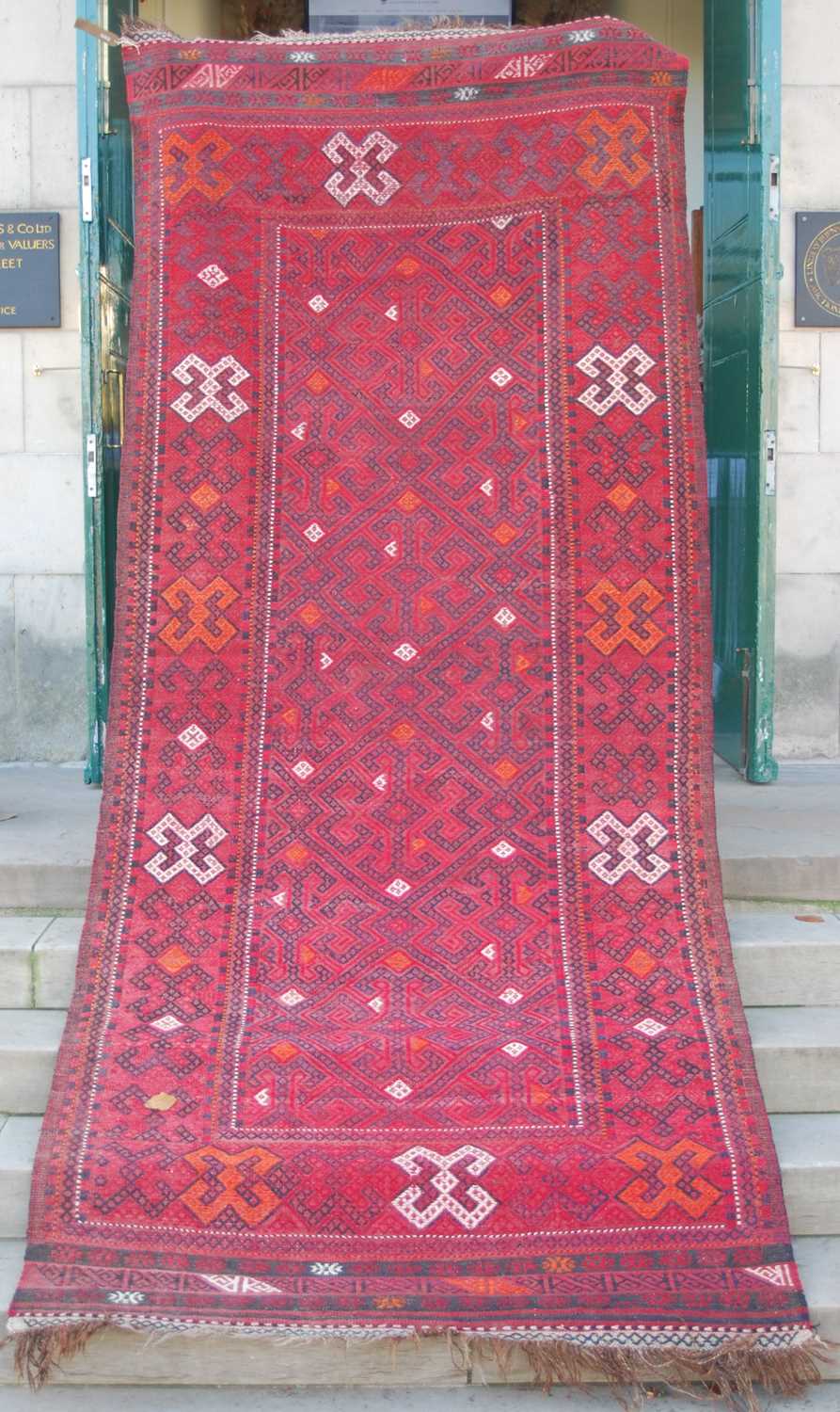 A Persian flatweave long rug, early to mid-20th century, the rectangular field centred with four