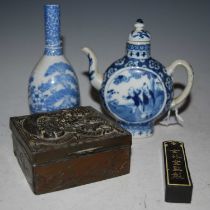 A Chinese blue and white porcelain moon-shaped teapot and cover, Qing Dynasty, decorated on each