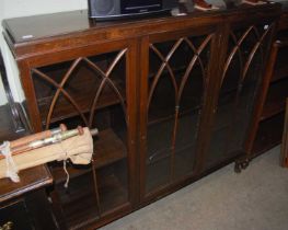 An early 20th century dark wood Astragal glazed three-door bookcase raised on four cabriole supports