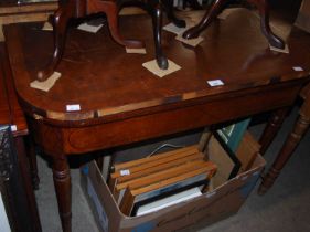 A 19th century mahogany fold-over games / card table with green baize liner, raised on four turned